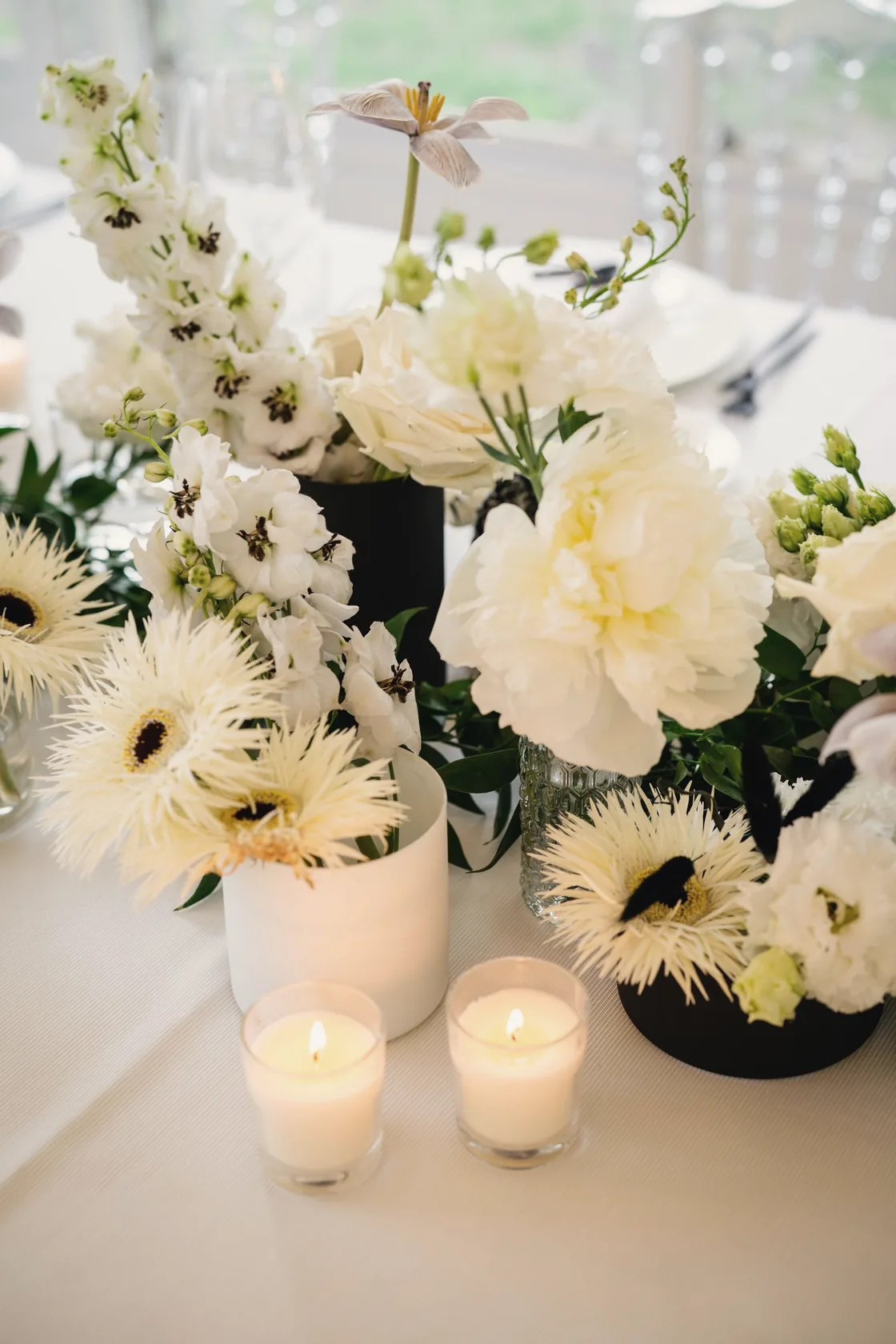 White flowers and lit candles on a reception table