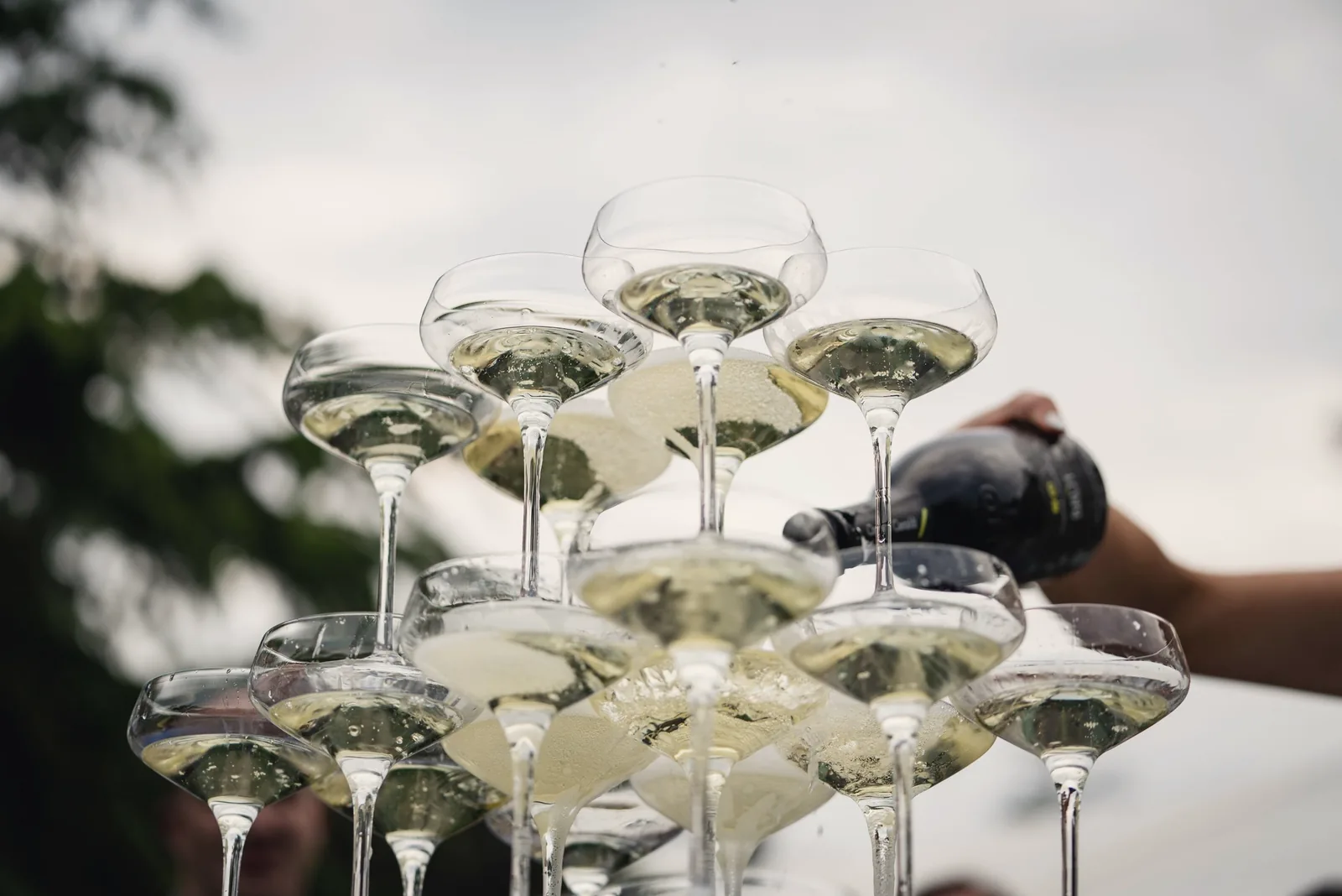 Champagne poured into a tower of coupe glasses