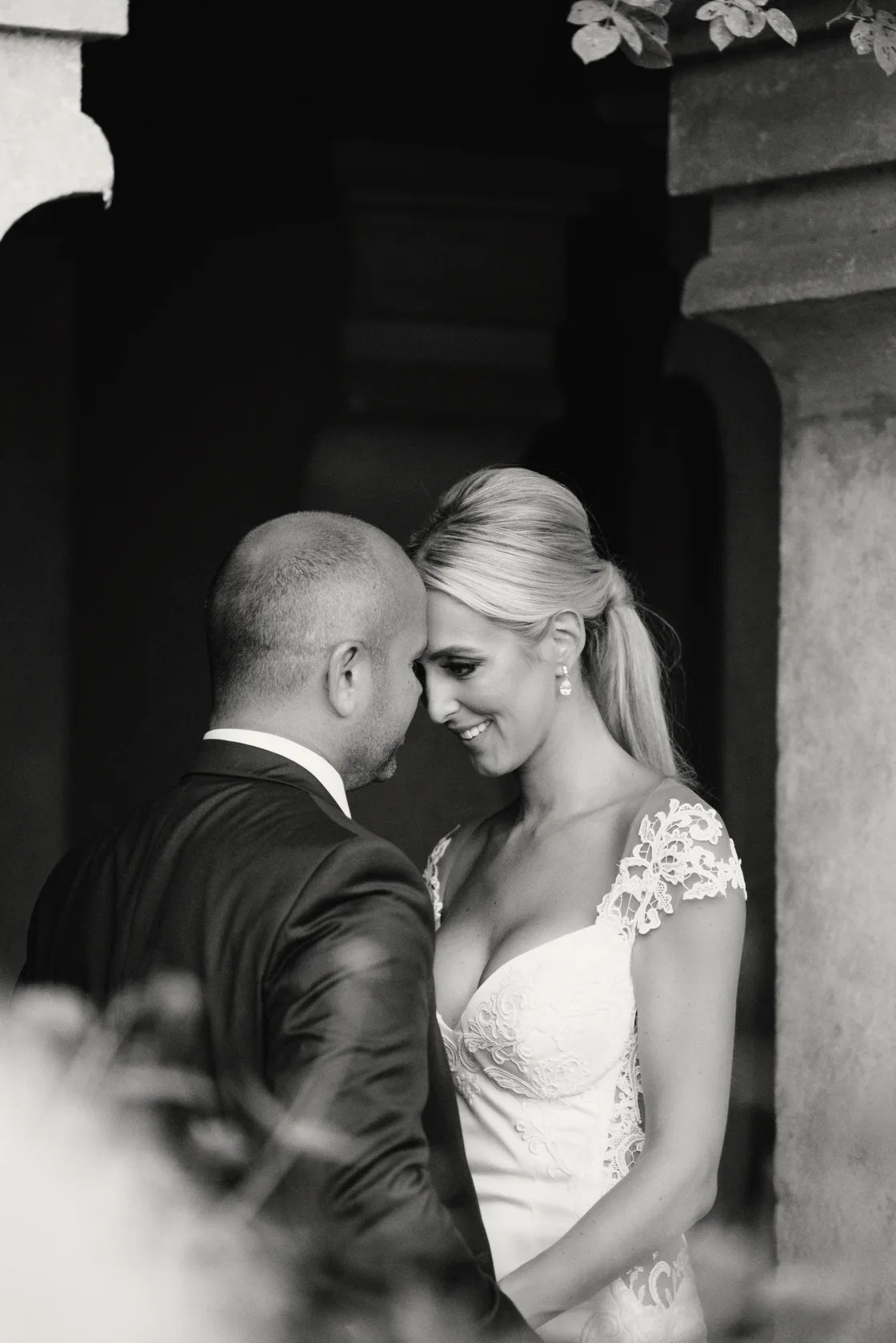 Black and white portrait of a couple embracing in a shaded doorway