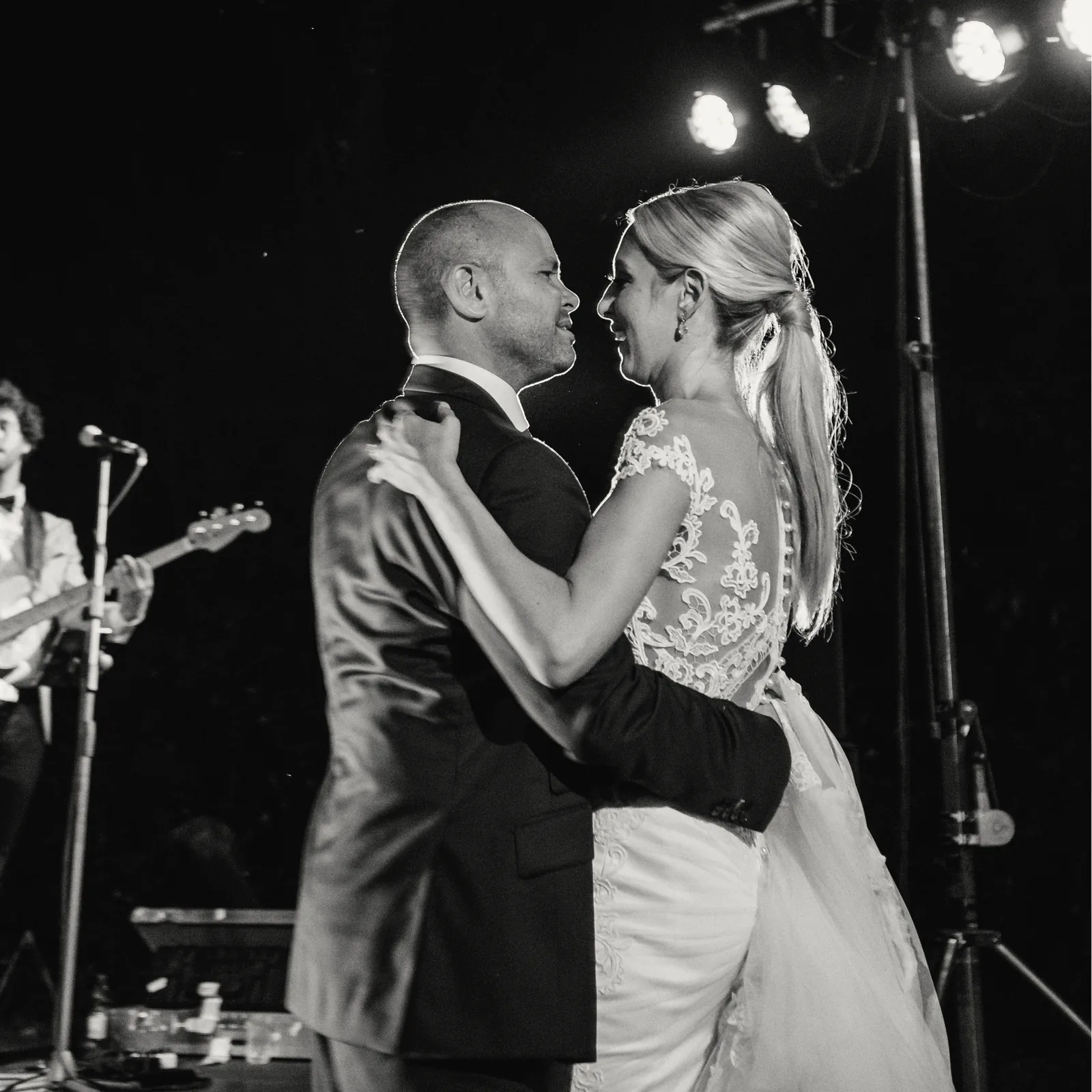 Black and white photo of a couple's first dance in front of the band